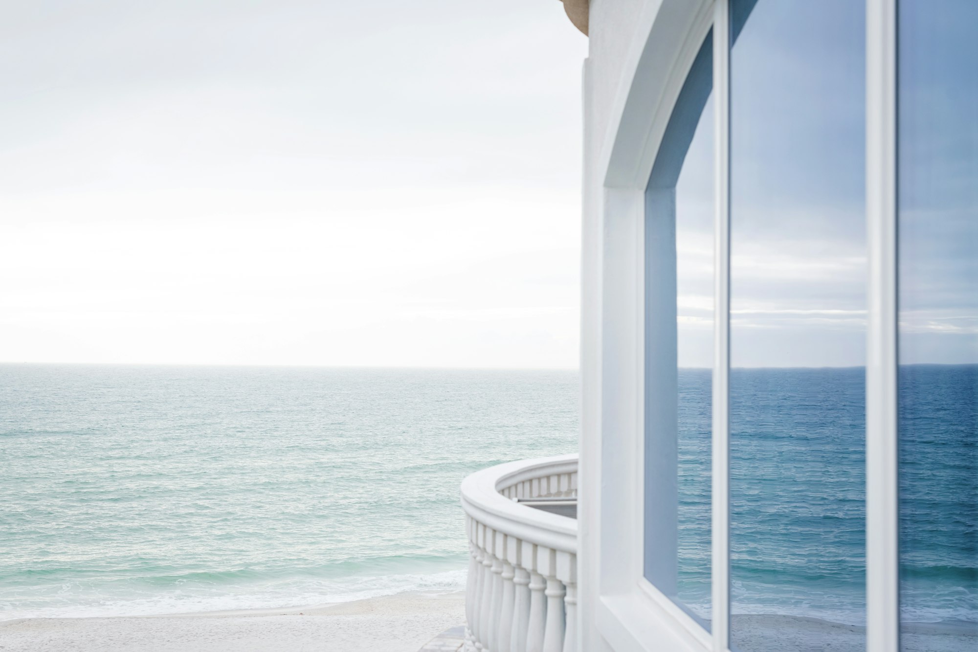 Balcon blanc face à la mer, lumière douce du matin